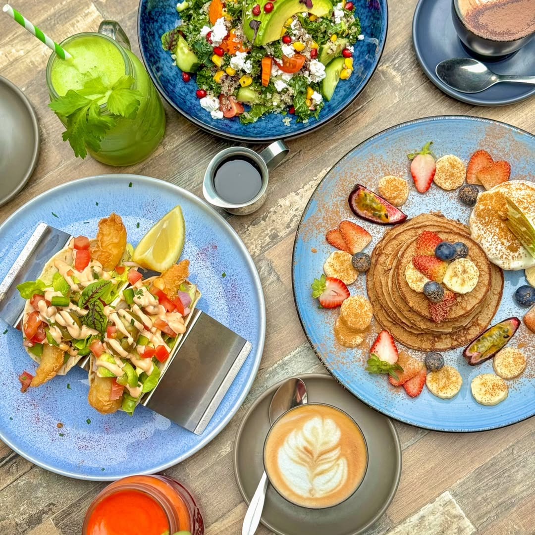 Overhead brunch spread with pancakes, salad, tacos and coffee