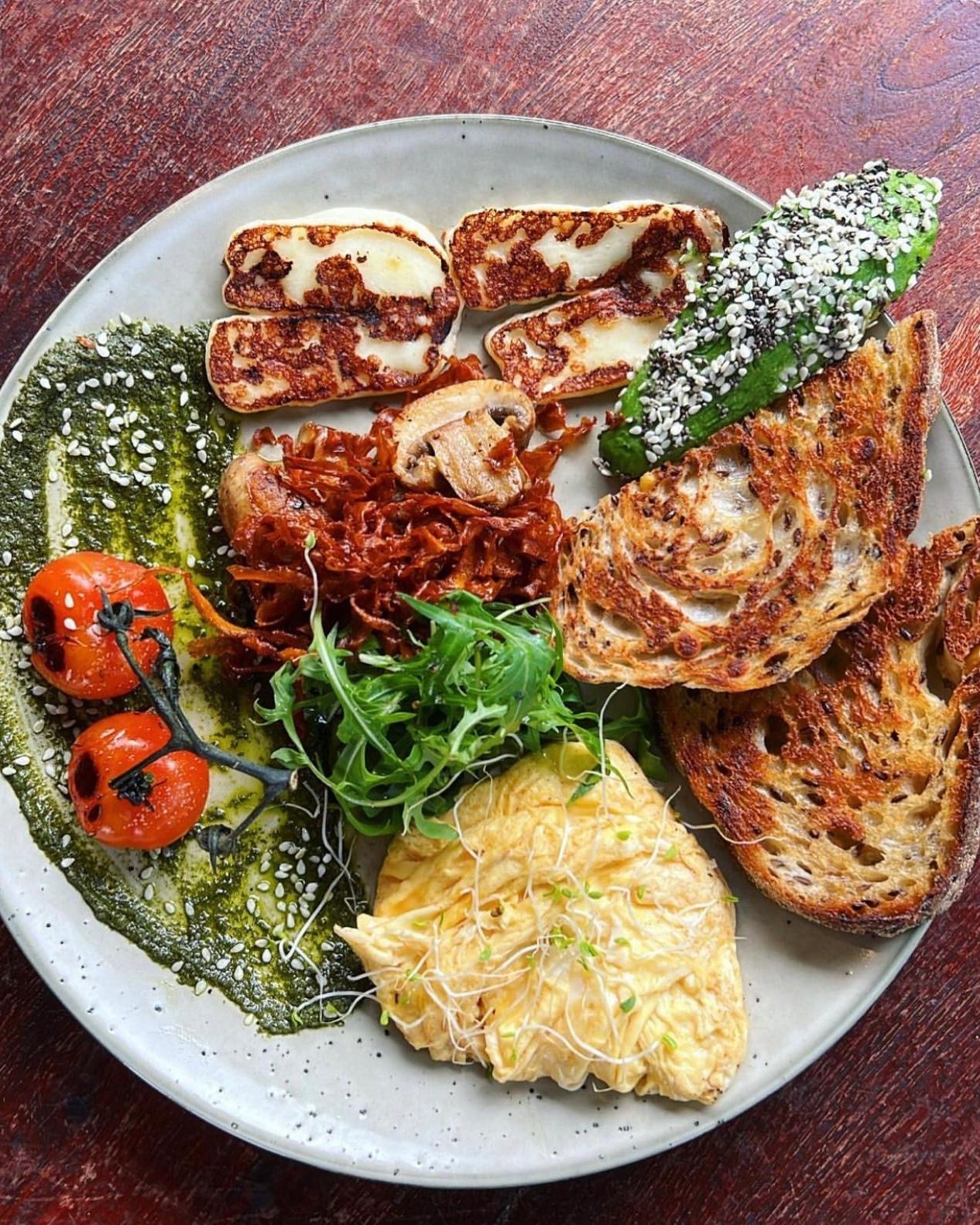Big breakfast with scrambled eggs, halloumi, avocado and sourdough